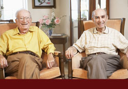 Elderly gentlemen in nursing home sitting and smiling - Click for "MassHealth (Medicaid) Planning Service"